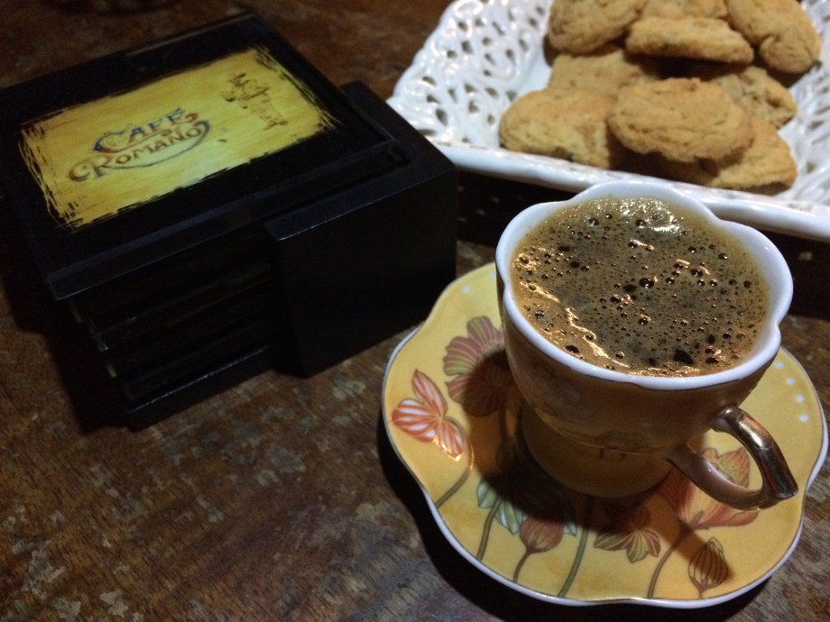 Freshly brewed coffee in a demitasse and cookies.